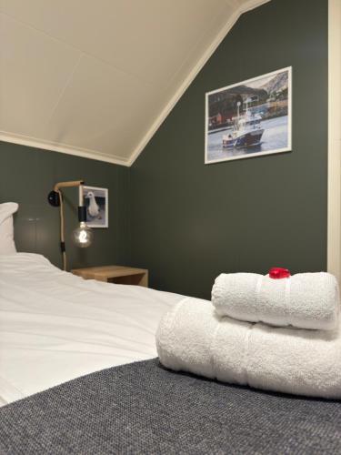 a bedroom with a bed with two towels on it at Fishermans Villa Ballstad - Lofoten in Ballstad