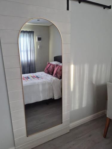 a bedroom with a mirror with a bed in it at Blouberg Guest suite, 3 km to the beach, Wi-Fi inc in Parklands