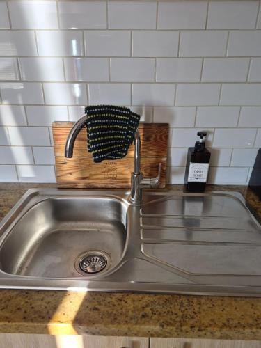 a kitchen sink with a black and white sponge at Blouberg Guest suite, 3 km to the beach, Wi-Fi inc in Parklands