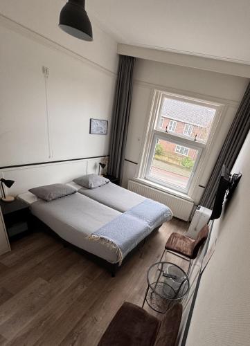 a bedroom with a large bed and a window at Stad & Strandhotel Elisabeth in Vlissingen
