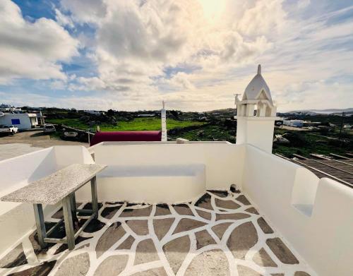 balcone con tavolo e panca sul tetto di Villa Vasilis a Mykonos Città