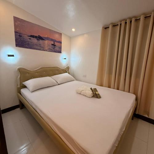 a small bedroom with a bed with white sheets at Camila Hostel Coron in Coron