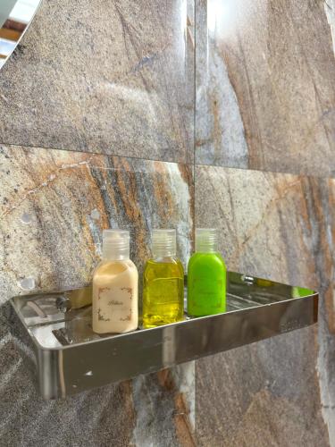 three bottles of essential oils sitting on a shelf at Dew Ceylon Villa Negombo in Negombo