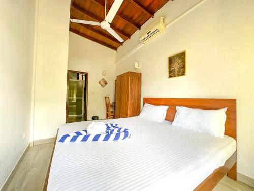 a bedroom with a large bed with white sheets at Dew Ceylon Villa Negombo in Negombo