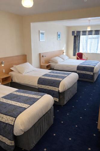 ein Hotelzimmer mit drei Betten in einem Zimmer in der Unterkunft Laguna Hotel in Bournemouth