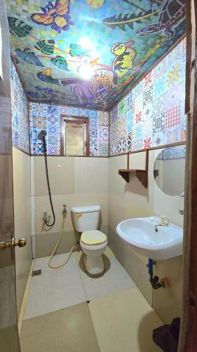 a bathroom with a toilet and a sink at YOLINDA's TOURIST INN in El Nido
