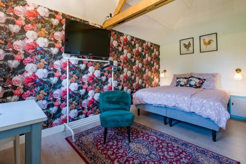 a bedroom with a bed and a tv and a chair at Zalk blijven slapen in Zalk