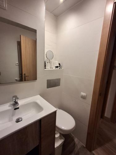 a bathroom with a sink and a toilet and a mirror at Candela's Beach Port in El Masnou