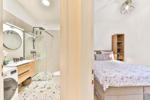 a small bedroom with a bed and a bathroom at IPM Apartments Kaštela, parking, pool, 10 minutes from Split airport in Kaštela