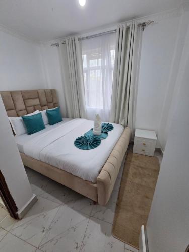 a large bed in a room with a large window at Waridi Homes-2 BR Naivegas Apartments, Naivasha in Munyu