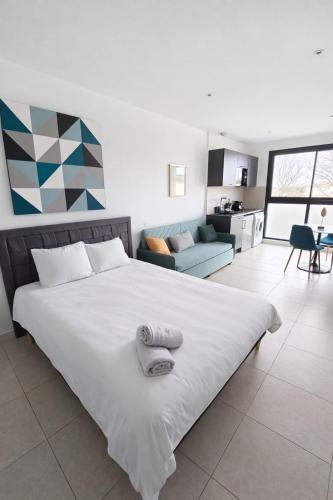 a bedroom with a large bed and a living room at studio balcon, centre ville, parc expo, Arena in Pérols