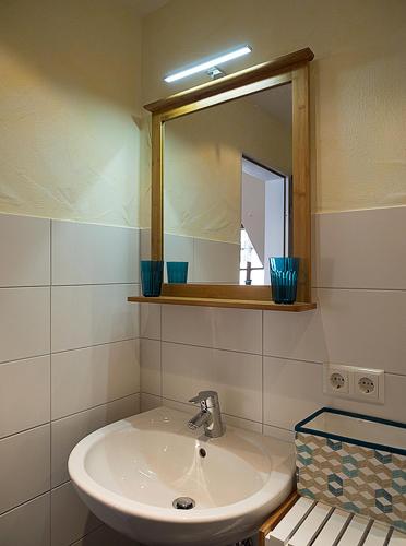 a bathroom with a sink and a mirror at Ferienwohnung Alte Schmiede in Burkheim
