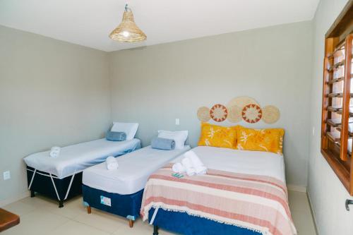 a bedroom with two twin beds and a lamp at Chalé sol de Macapá 1- Refúgio Pertinho do Mar in Luis Correia