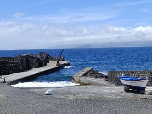a small boat sitting on the ground near the ocean at Casa do Guardião in Madalena