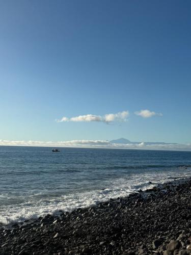 a boat in the water on a beach at Las Medinas Apartamentos in Las Palmas de Gran Canaria