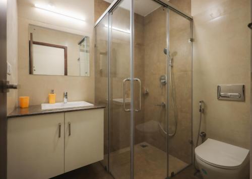 a bathroom with a shower and a toilet and a sink at River Whisper Villa in Cochin