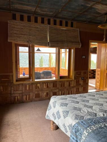 a bedroom with a bed in a room with windows at verse hunza in Karimabad Hunza