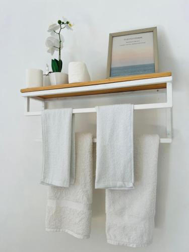 a shelf with white towels on a wall at Himandhoo sweet dreams in Himandhoo 