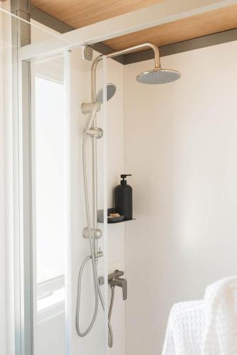 a shower in a bathroom next to a window at Mobile-Home Living in Gilsdorf