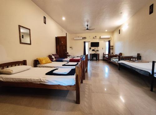 a room with a bunch of beds in it at Art cafe in Auroville