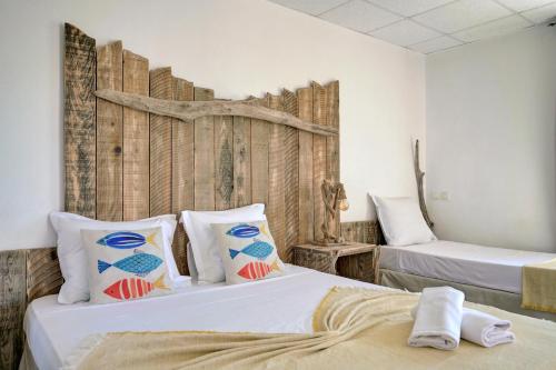 a bedroom with two beds and a wooden wall at Hotel Camille in Saintes-Maries-de-la-Mer