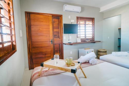a room with two beds and a wooden door at Chalé Sol de Macapá 2 - Kitesurf, Vento & Paraíso in Luis Correia