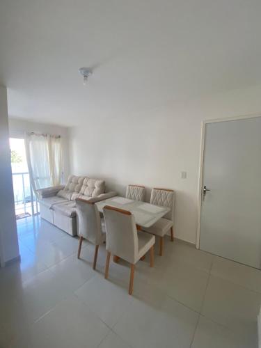 a living room with a couch and a table and chairs at Lar caminho da Ilha in Igarassu