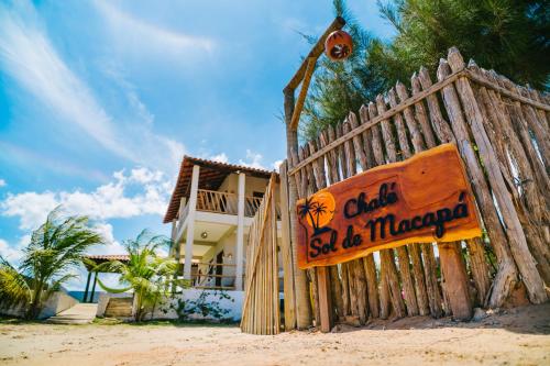 a wooden gate on the beach in front of a house at Chalé Sol de Macapá 2 - Kitesurf, Vento & Paraíso in Luis Correia