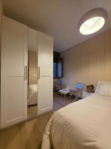 a bedroom with a bed and a large white cabinet at Hope Home Trentino in San Martino di Castrozza