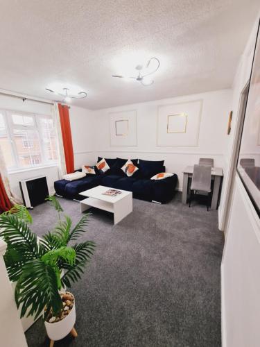 a living room with a couch and a table at Elisha's City Apartment in Hackbridge