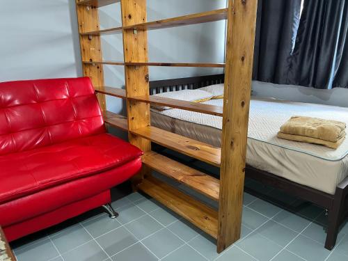 a wooden bunk bed with a red chair and a red couch at Impact Arena C5 by Jintana in Thung Si Kan