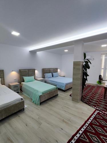 a bedroom with two beds and a rug at Sokaku Apartment in Gjirokastër