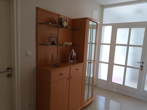 a room with a wooden cabinet and a large window at Apartman Blaženka in Kampor