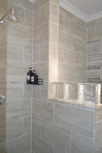 a bathroom with a gray tiled wall at Dulelo Guest House Gaborone in Gaborone