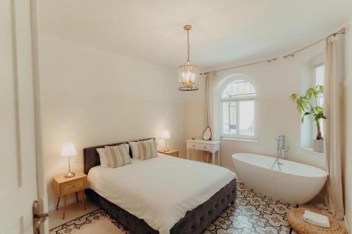 a bedroom with a bed and a bath tub at Sonnenblick in Polanica-Zdrój
