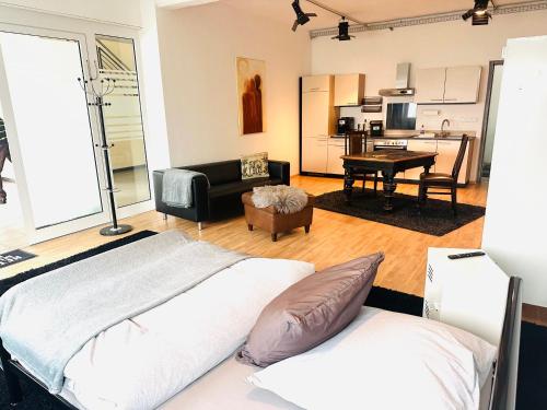 a bedroom with a bed and a living room at 40 qm große Studiowohnung zentral gelegen - direkt in Groß-Umstadt - 300 m bis zum Marktplatz in Groß-Umstadt