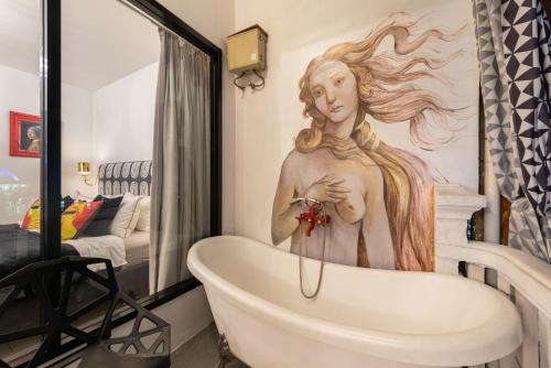 a bathroom with a bath tub with a statue of a woman at Studio Kunst in Bangkok