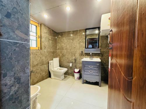 a small bathroom with a toilet and a sink at Id villa in Tangmarg
