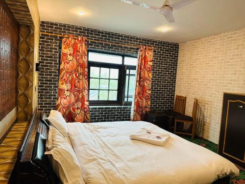 a bedroom with a bed and a brick wall at Id villa in Tangmarg