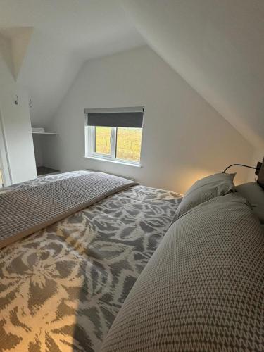 an attic bedroom with a bed and a window at An Camus Ballyliffin in Ballyliffin