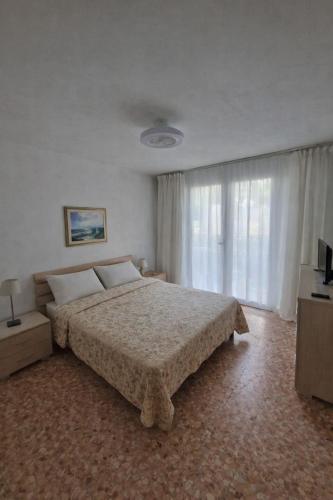 a bedroom with a bed and a large window at Villa Aurora in Tirrenia