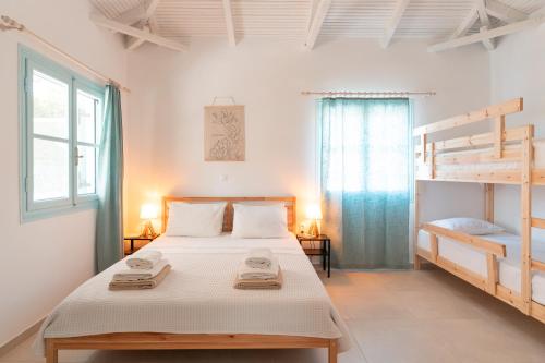 a bedroom with a bed and two bunk beds at Varka Bungalows in Methoni