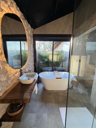a bathroom with a tub and a glass shower at Rancho Mavi Hospedagem Colônia Witmarsum in Palmeira