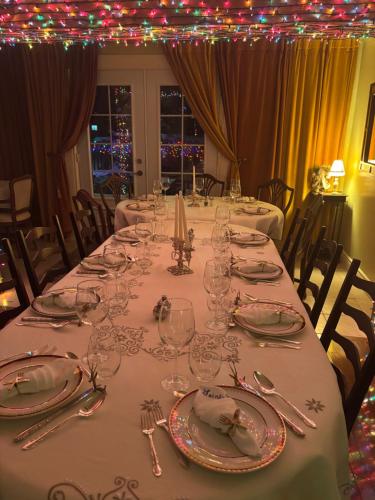a long table with glasses and silverware on it at Le Saint Louis de lotbinière in Lotbinière