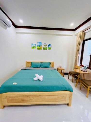 a bedroom with a bed with two white towels on it at SUN Homestay Vĩnh Hy in Vĩnh Hy