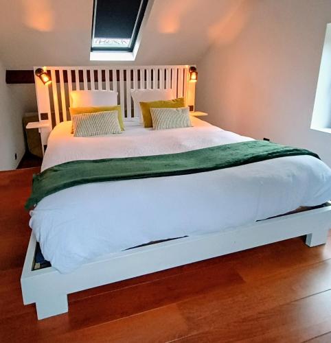a bedroom with a large white bed in a room at Au Coin du Bois in Theux