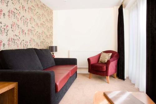 a living room with a couch and a chair at Redesdale Arms Hotel in Moreton in Marsh