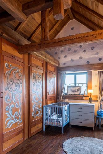 a room with a crib and a wooden ceiling at Ranczo Pod Strzechą in Stara Kamienica
