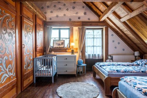 a bedroom with two beds and a crib in it at Ranczo Pod Strzechą in Stara Kamienica