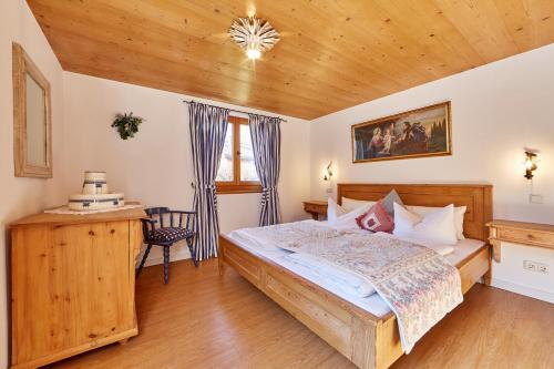 a bedroom with a large bed and a wooden ceiling at Föhrenhof Apartments in Farchant